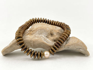 Armband aus kupferfarbenen Steinen mit Perle - Armband Leticia an ein Holzstück gelehnt